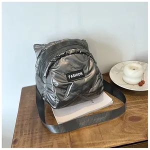 Silver quilted puffer handbag with FASHION label on a wooden table setup