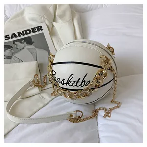 Macro shot of white basketball-shaped round bag with black stripes and gold chain strap