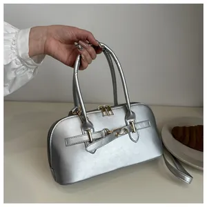 Detailed close-up of metallic silver mirror tote bag with gold buckle and crossbody strap