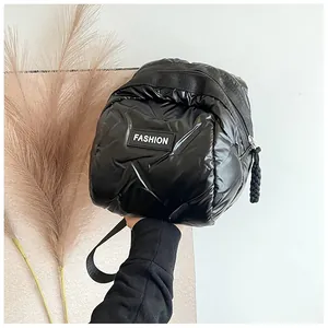 Macro detail of glossy quilted nylon bag with black zipper and white Fashion label
