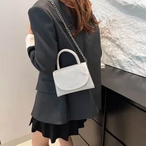 Silver rhinestone mini crossbody bag with metal chain and white leather flap detail