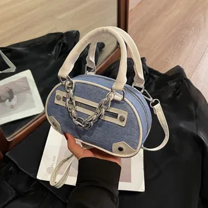 Blue denim oval handbag with white leather trim and silver chain handle detail