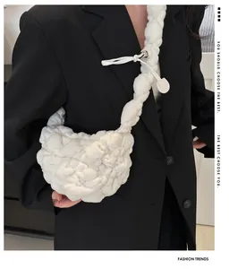 Close-up of white plush pleated cloud bag with soft texture and matching shoulder strap