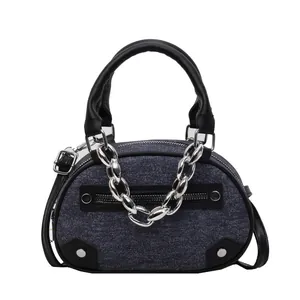 Sac à bandoulière en denim bleu avec bordure en cuir noir et grosse chaîne en métal argenté