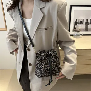Minimalist leopard print drawstring bucket bag with black strap for a trendy stylish look