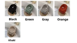 Detail view of corduroy mini backpacks with cartoon big eye patches in five diverse colors