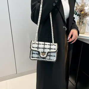 Klassieke zwart-witte tweed schoudertas met kettingriem en goudkleurige metalen sluiting