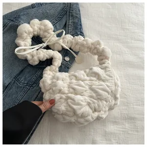Close-up of white bubble textured plush bag with bow detail on casual denim jacket