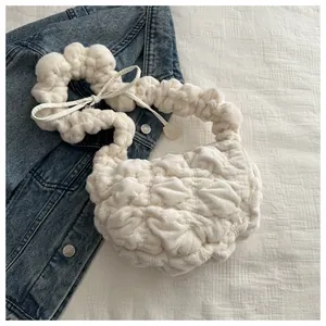 Close-up of white ruched plush shoulder bag showing soft cloud-like texture and details