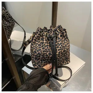 Sac seau léopard avec cordon en cuir noir et détails métalliques dorés élégants