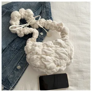 Detailed view of white plush pleated handbag next to a phone showing texture and size