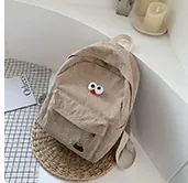 Detail of khaki corduroy backpack with cartoon eye patches and front zipper pocket