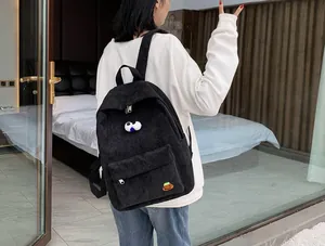 Close-up of black corduroy backpack featuring unique cartoon eye and potato patches