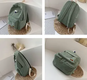 Detail view of the green corduroy backpack with eye decor and mountain embroidery