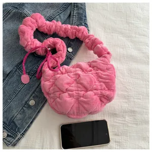 Detail of bright pink plush ruched handbag with scrunchie handle and soft texture