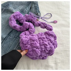 Close-up of purple plush ruched bag with soft texture and metallic adjustment buckle