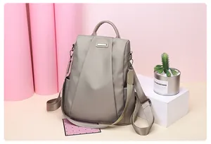 Detail of khaki nylon backpack featuring smooth texture and premium metal hardware