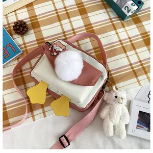 Dettaglio della borsa a tracolla a forma di papera in nylon con ciondolo a forma di orso
