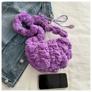 Close-up of small purple cloud-textured plush handbag with ruffled shoulder strap detail