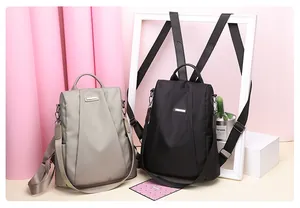 Detail of waterproof nylon anti-theft backpacks in black and khaki with metal logo