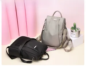 Dual view of black and grey anti-theft nylon backpacks on minimalist display stands