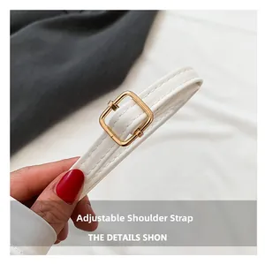 Detalle de la correa ajustable de cuero blanco con hebilla de metal dorado elegante