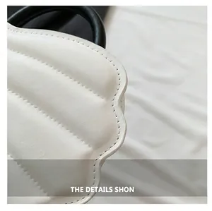 Vista de cerca de bolso de cuero acolchado blanco con diseño de borde festoneado