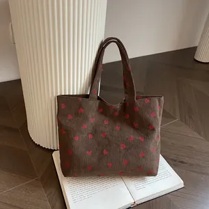 Brown corduroy tote bag with strawberry pattern and dual handles for daily commute