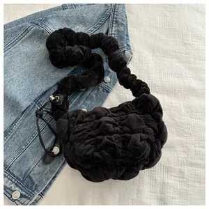 Detail of black plush pleated cloud bag with soft fluffy texture and drawstring detail