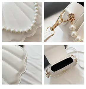 Detalles del bolso de concha blanco con asa de perlas y herrajes dorados