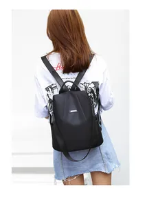 Rear view of a black anti-theft nylon backpack shown on model for size and fit
