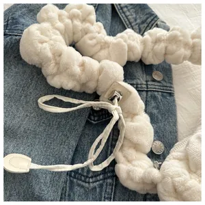 Close-up of white plush shoulder strap with metal buckles and soft pleated texture