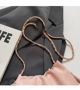 Détail d'un sac seau plissé rose pâle doté d'une chaîne en métal doré de haute qualité