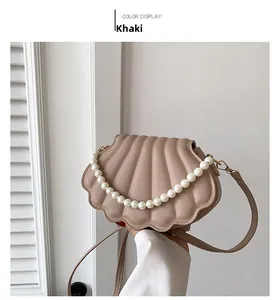 Detalle del bolso bandolera kaki en forma de concha, cuero PU acolchado y cadena de perlas