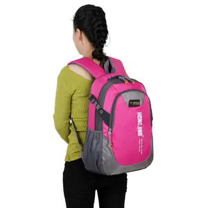 Outdoor student backpack in rose red and gray with mesh side pockets shown on model