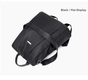 Flat display of black nylon anti-theft backpack featuring a silver rectangular logo buckle