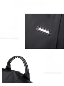 Detail of black nylon anti-theft backpack showing the durable handle and decorative metal plate