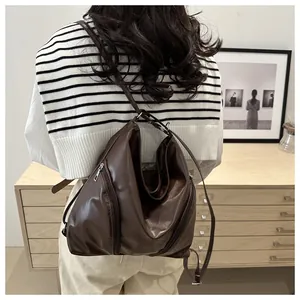 Detail view of the brown PU leather tote showing functional side zipper and soft texture
