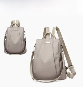 Detail view of khaki anti-theft nylon backpack with leather handle and smooth metal zipper