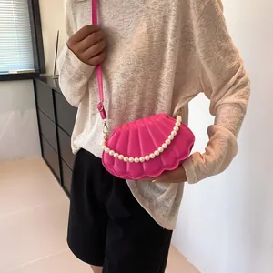 Bolso bandolera de concha rosa fucsia con asa de perlas y cadena dorada chic