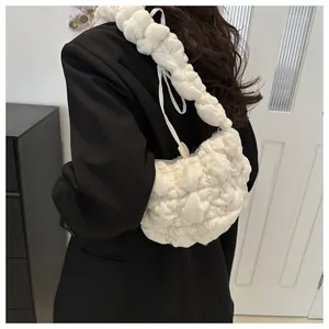 Detail of white quilted cloud bag with pleated strap texture and soft fabric design