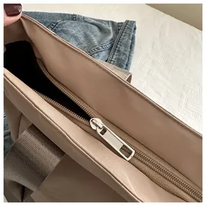 Detail view of the high-quality silver metal zipper closure on this khaki tote bag