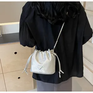 Détail du sac seau métallisé argenté avec plaque triangulaire et bandoulière en chaîne