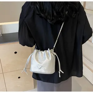 Sac seau métallisé argenté avec bandoulière chaîne porté en travers du corps