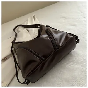 Detail of dark brown PU leather tote with dual vertical zippers and soft glossy texture