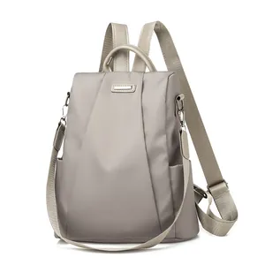 Close-up of taupe nylon anti-theft backpack with polished silver hardware and texture