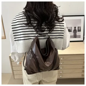 Deep brown soft leather backpack worn by a model in a cozy minimalist indoor room setting
