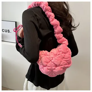 Detail of bright pink plush quilted shoulder bag showing texture on a model