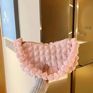 Détail du sac à main plissé à texture bulles roses montrant la finition froncée