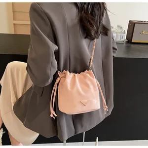 Sac seau rose avec cordon de serrage et bandoulière chaîne porté en sac à bandoulière